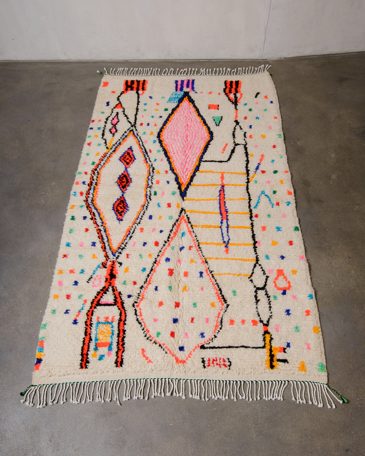 Berberlin Azilal rug made of fluffy wool and cotton, laying flat on a concrete floor.
